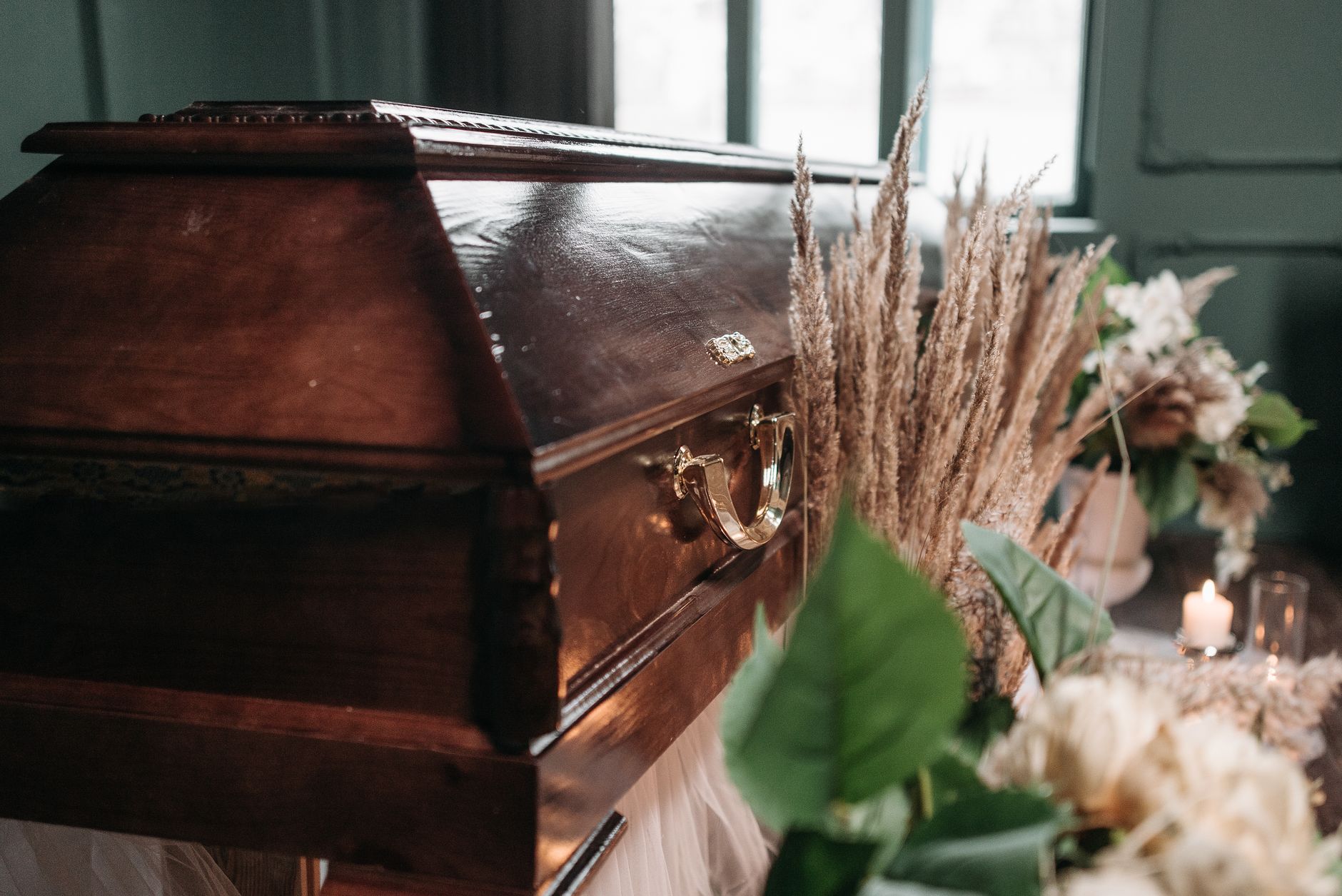 An elegantly arranged casket with white flowers and candles